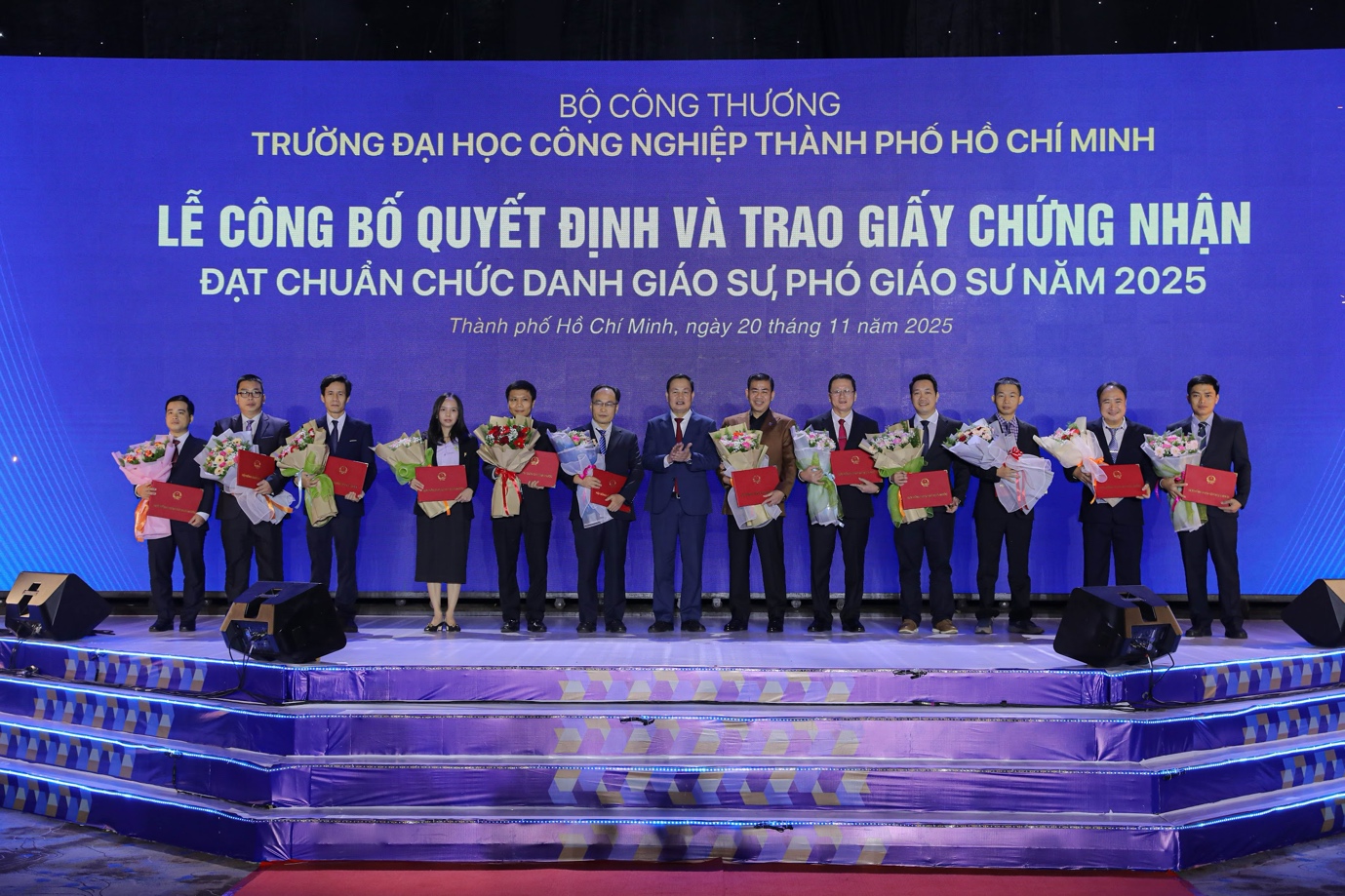 GS. TS Nguyễn Hữu Đức (đứng giữa) trao Giấy chứng nhận cho 12 giảng viên IUH đạt tiêu chuẩn chức danh Giáo sư/Phó Giáo sư năm 2025